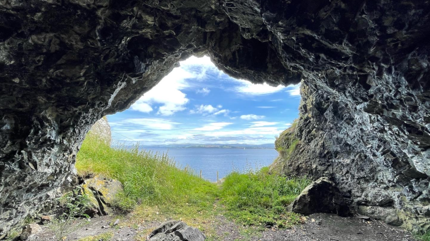 a cave with a view of the ocean and grass - psychotherapy