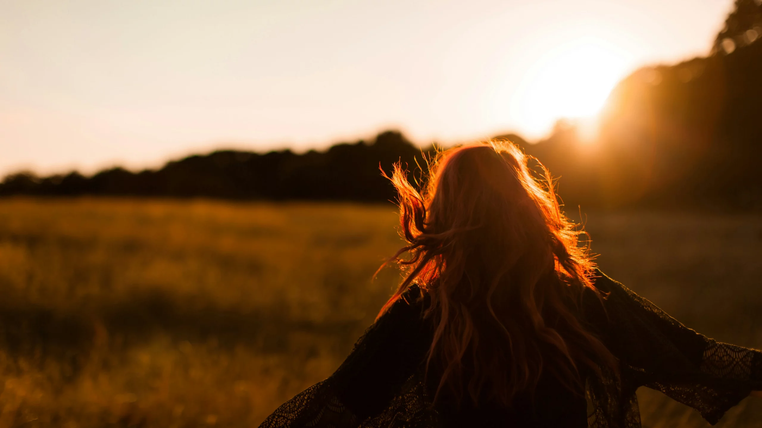 Woman enjoying sunset in a field.